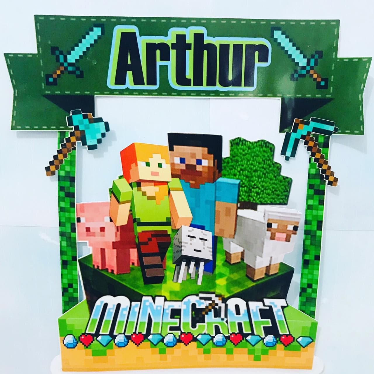Painel decorativo em arco do tema Minecraft com faixa 'Arthur' e picaretas de diamante nas laterais, moldura vazada ao centro e, na base, os personagens com um porco, uma ovelha e um golem de neve sobre uma plataforma de bloco